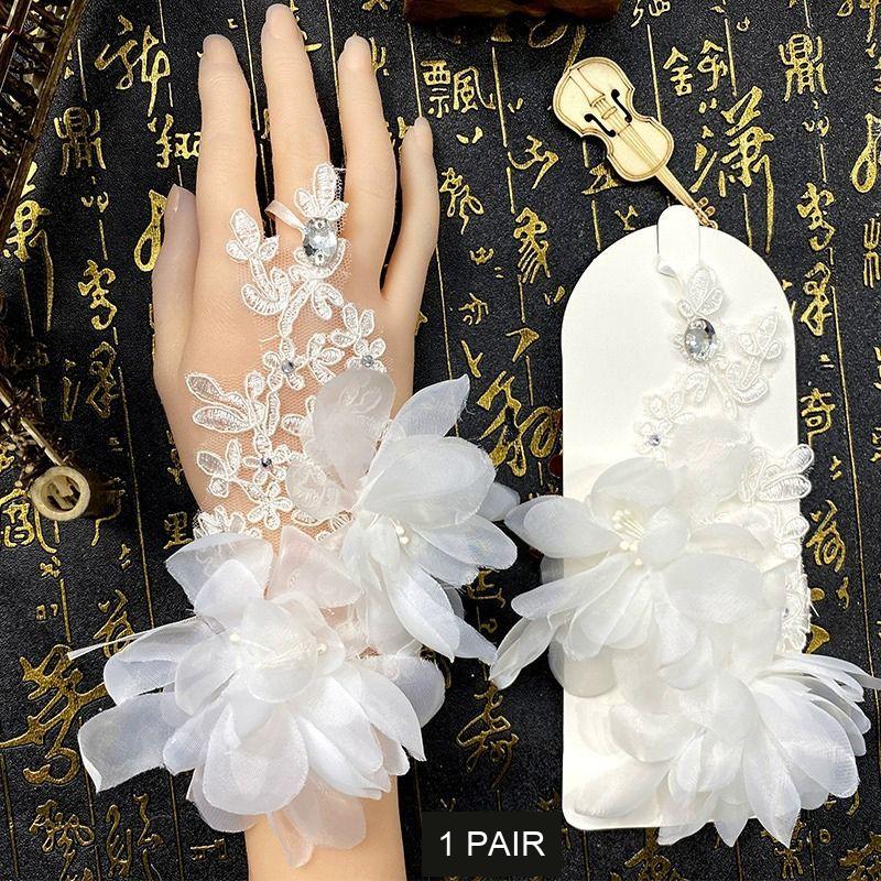 One pair of white floral bridal hand accessories with lace, fabric flowers and decorative stones