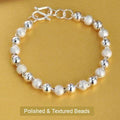 Silver-tone bracelet with alternating polished and textured round beads and an extension chain