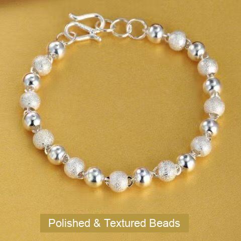 Silver-tone bracelet with alternating polished and textured round beads and an extension chain