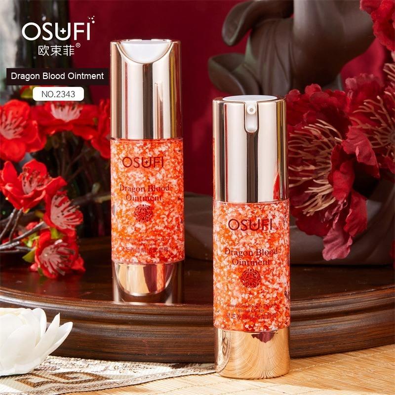 OSUFI Dragon Blood Ointment No. 2343 bottles photographed among red flowers