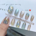 Blue cat-eye press-on nails with raised floral details and gold-tone accents, size M